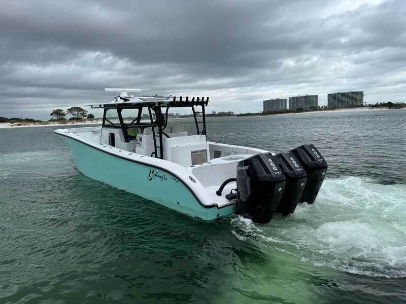 Slide: The Image of 2023 Yellowfin 42 Offshore boat cruising on a cloudy day with triple outboard engines. - 21