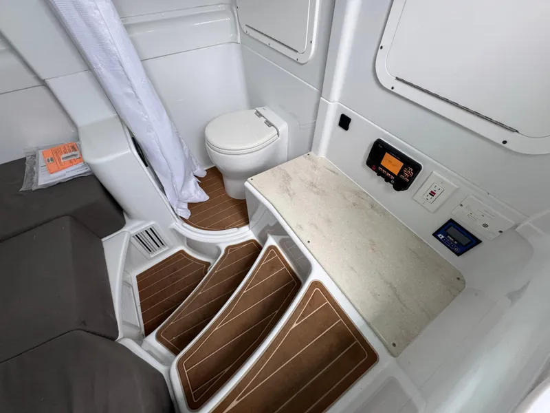 Slide: The Image of 2023 Yellowfin 42 Offshore boat interior with toilet, wooden steps, and control panel. - 37