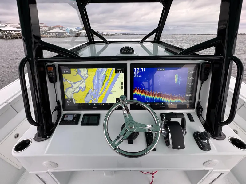 Slide: The Image of 2023 Yellowfin 42 Offshore boat dashboard with navigation screens and steering wheel. - 39