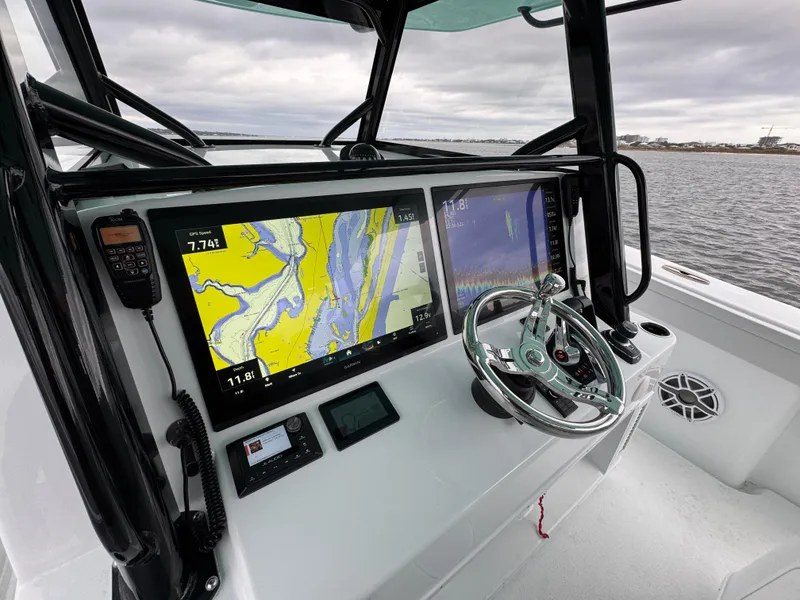 Slide: The Image of 2023 Yellowfin 42 Offshore boat dashboard with navigation screens and steering wheel. - 42