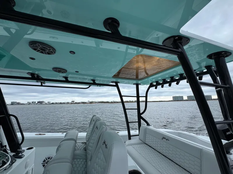 Slide: The Image of 2023 Yellowfin 42 Offshore boat interior with seating, overlooking calm waters. - 47