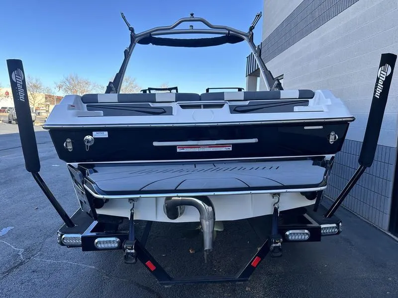 Slide: The Image of 2024 Malibu 21 LX-R boat, rear view, on trailer, parked outdoors. - 5