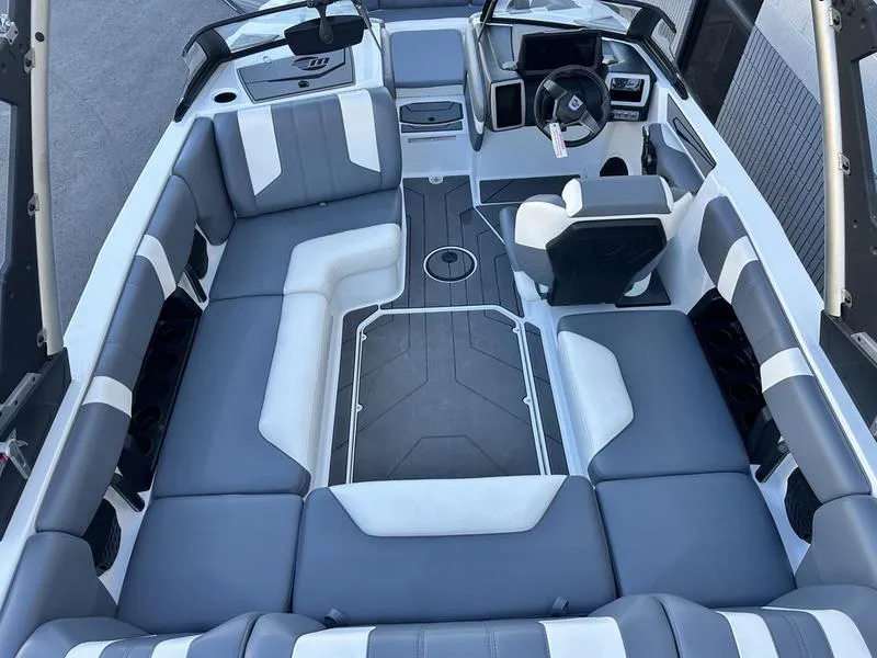 Slide: The Image of 2024 Malibu 21 LX-R boat interior with gray and white seating, modern dashboard. - 9