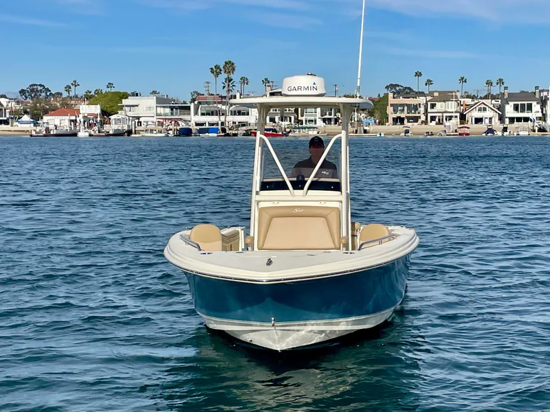Slide: The Image of 2020 Scout 215 XSF boat on water, with coastal houses in the background. - 1