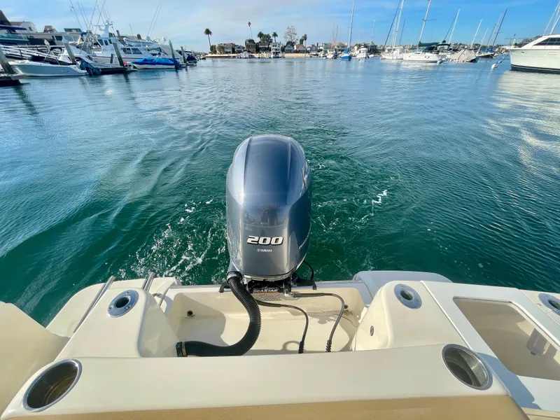 Slide: The Image of 2020 Scout 215 XSF boat with 200 HP engine in a marina setting. - 11