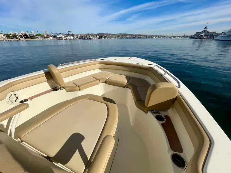 Slide: The Image of 2020 Scout 215 XSF boat interior with tan seating, overlooking calm waters and distant shoreline. - 15