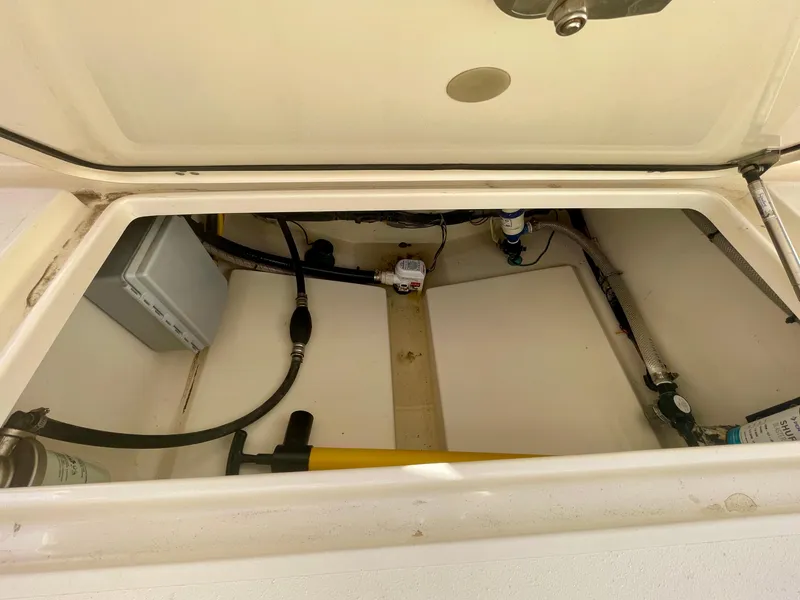 Slide: The Image of 2020 Scout 215 XSF boat storage compartment with visible hoses and equipment. - 19