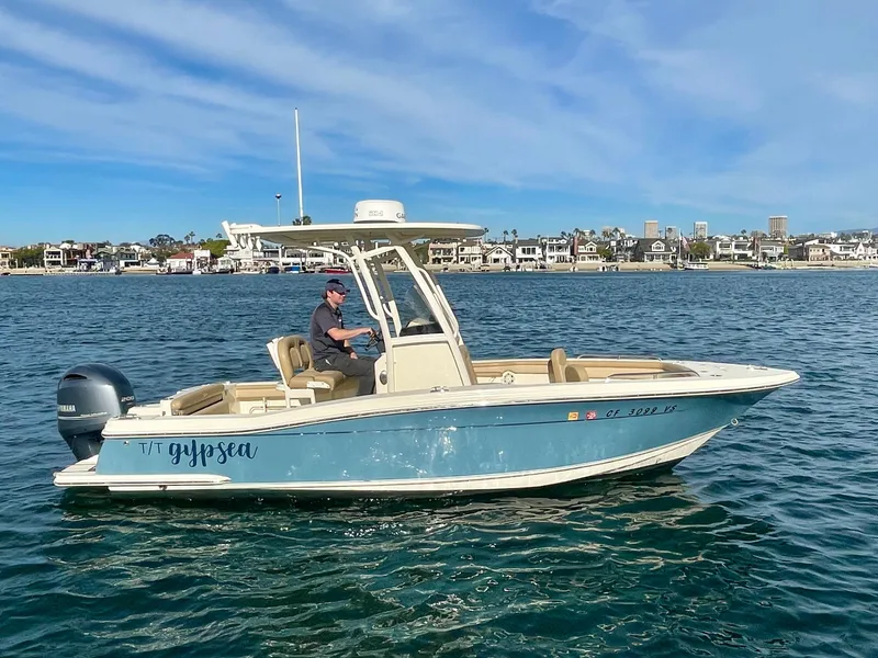 Slide: The Image of 2020 Scout 215 XSF boat cruising on a sunny day in coastal waters. - 2