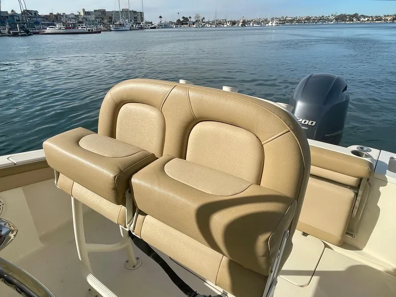 Slide: The Image of 2020 Scout 215 XSF boat interior with tan seating, overlooking a marina. - 22