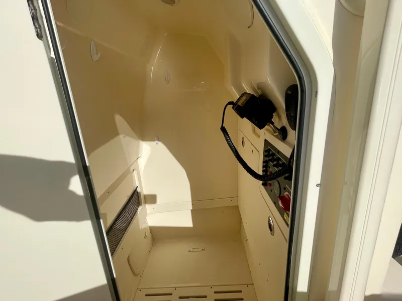 Slide: The Image of 2020 Scout 215 XSF boat interior cabin with control panel and storage space. - 29