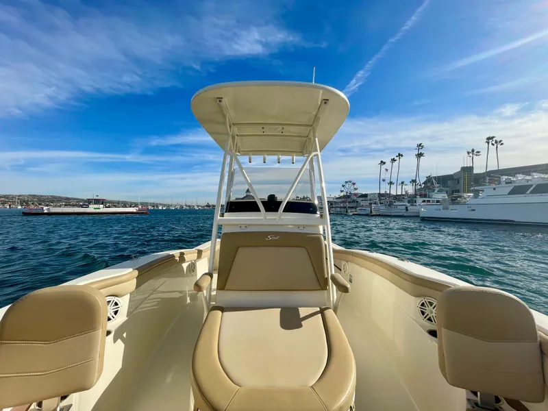 Slide: The Image of 2020 Scout 215 XSF boat on water, clear sky, marina background. - 30