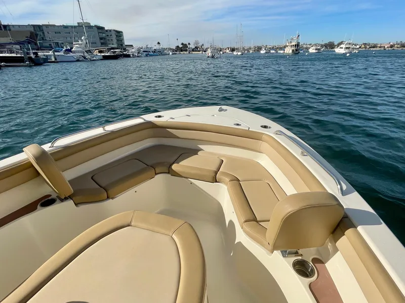 Slide: The Image of 2020 Scout 215 XSF boat with tan seating, docked in a marina. - 32