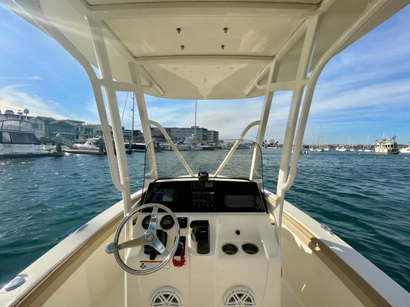 Slide: The Image of 2020 Scout 215 XSF boat helm with marina view, clear skies, and calm waters. - 35