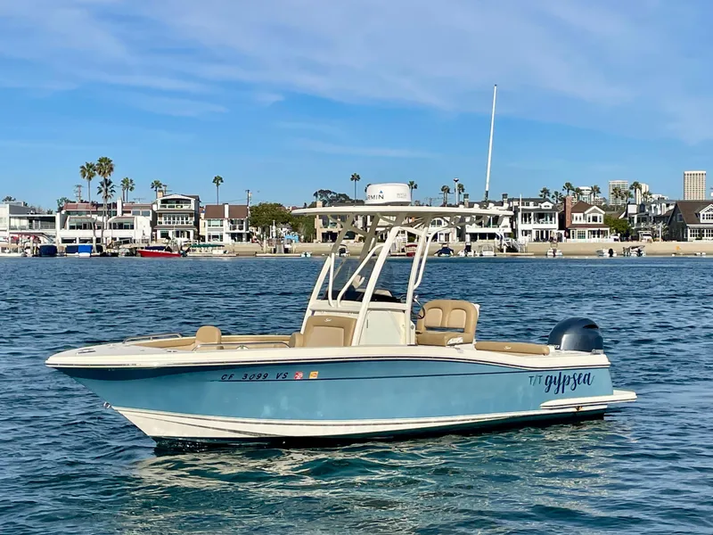 Slide: The Image of 2020 Scout 215 XSF boat on water with coastal background and clear sky. - 4