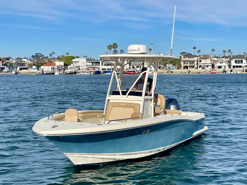 Slide: The Image of 2020 Scout 215 XSF boat on calm water near coastal homes. - 5