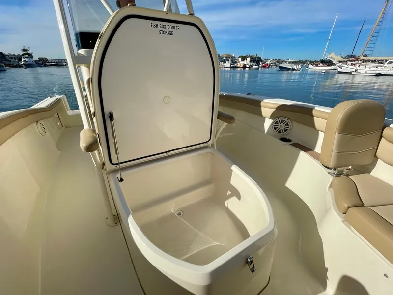 Slide: The Image of 2020 Scout 215 XSF boat with open fish box cooler storage, docked in a marina. - 6