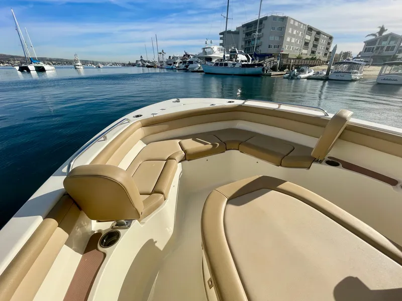 Slide: The Image of 2020 Scout 215 XSF boat interior with tan seating, docked in a marina. - 9