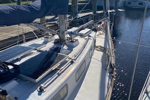 The Image of 1973 Tartan 34 sailboat with solar panels docked at a marina. - 1