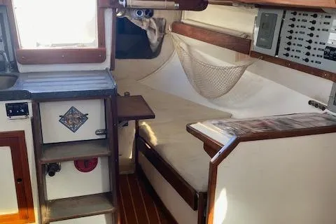 Slide: The Image of Interior of a 1973 Tartan 34 sailboat, featuring cozy seating and wooden accents. - 4