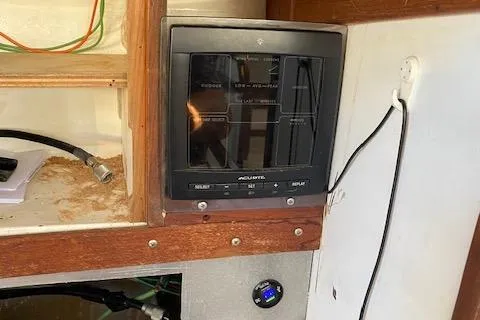 Slide: The Image of Control panel inside a 1973 Tartan 34 sailboat, featuring navigation and electrical components. - 8