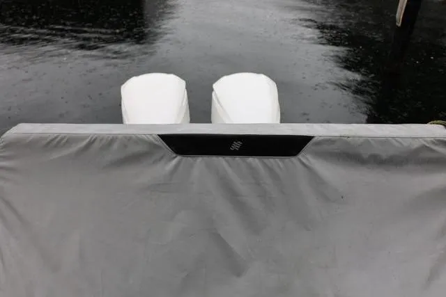 Slide: The Image of 2021 Four Winns V355 Coupe boat with covered engines on a calm water surface. - 10