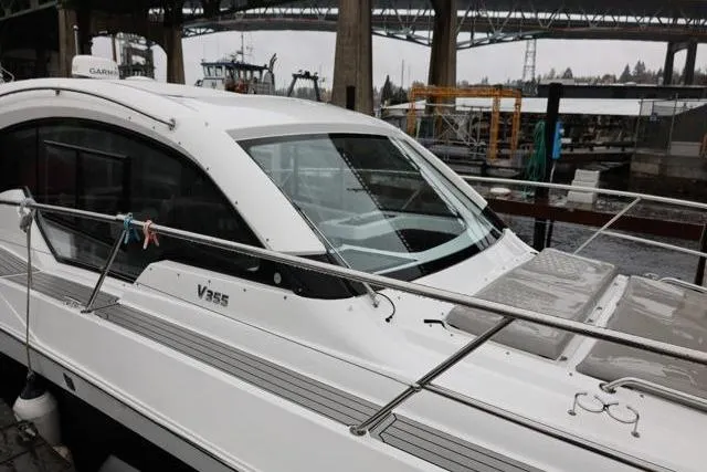 Slide: The Image of 2021 Four Winns V355 Coupe boat docked under a bridge. - 21