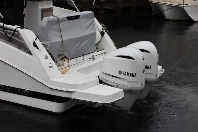 Slide: The Image of 2021 Four Winns V355 Coupe with twin Yamaha outboard engines in a marina setting. - 22
