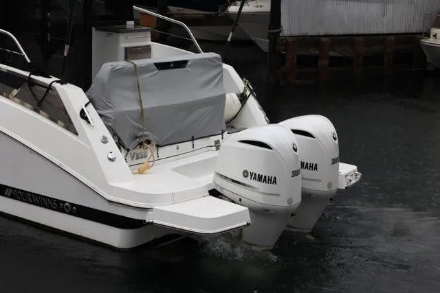 Slide: The Image of 2021 Four Winns V355 Coupe with dual Yamaha outboard motors docked in the water. - 23