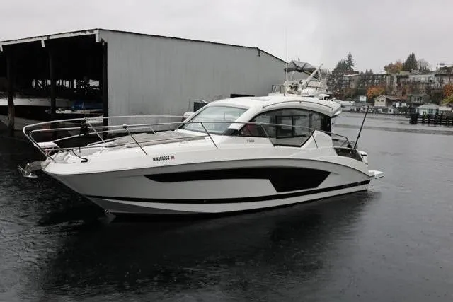 Slide: The Image of 2021 Four Winns V355 Coupe boat docked on a rainy day. - 27