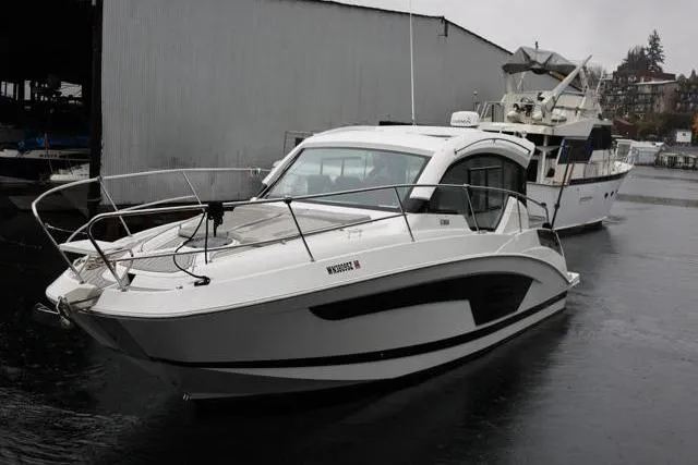 Slide: The Image of 2021 Four Winns V355 Coupe boat docked in a marina on a cloudy day. - 28