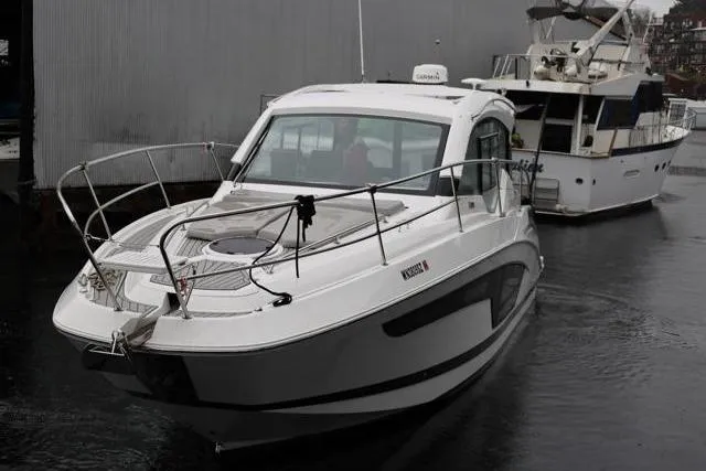 Slide: The Image of 2021 Four Winns V355 Coupe boat docked in a marina, overcast day. - 31