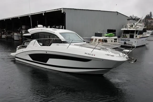 Slide: The Image of 2021 Four Winns V355 Coupe boat docked in a marina on a cloudy day. - 34