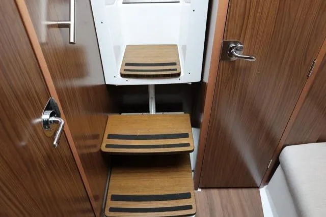 Slide: The Image of 2021 Four Winns V355 Coupe interior with wooden steps and modern design. - 49