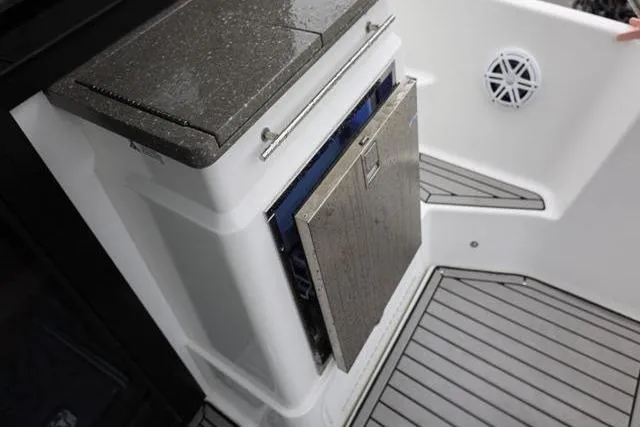 Slide: The Image of 2021 Four Winns V355 Coupe boat interior with open storage compartment and sleek flooring. - 5