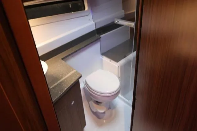 Slide: The Image of 2021 Four Winns V355 Coupe bathroom interior with modern fixtures and wood accents. - 51