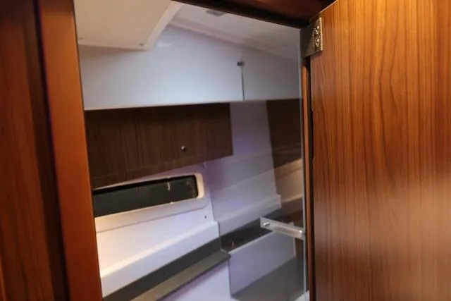 Slide: The Image of Interior view of 2021 Four Winns V355 Coupe, showcasing wooden cabinetry and modern design. - 52