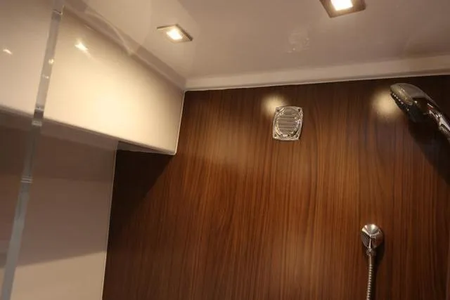 Slide: The Image of Interior of 2021 Four Winns V355 Coupe, featuring modern shower with wood paneling. - 63