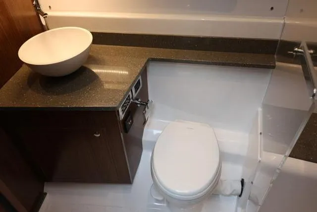 Slide: The Image of 2021 Four Winns V355 Coupe bathroom with modern sink and toilet. - 66