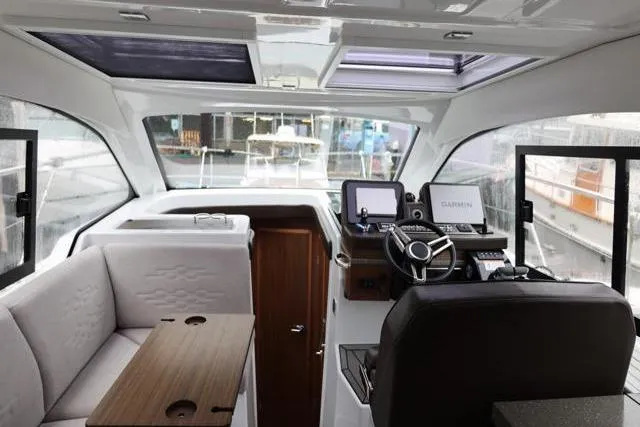 Slide: The Image of 2021 Four Winns V355 Coupe interior with helm, seating, and navigation equipment. - 86