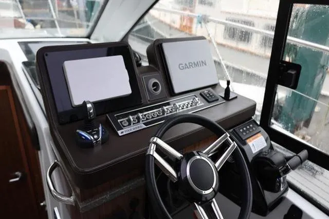 Slide: The Image of 2021 Four Winns V355 Coupe helm with Garmin navigation system and modern controls. - 87