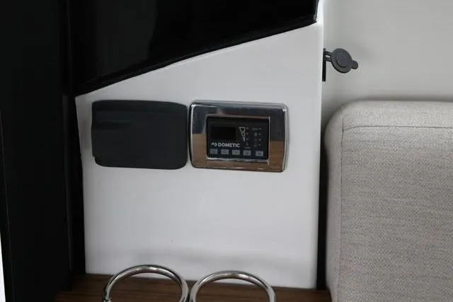 Slide: The Image of 2021 Four Winns V355 Coupe interior with Dometic control panel and cup holders. - 88