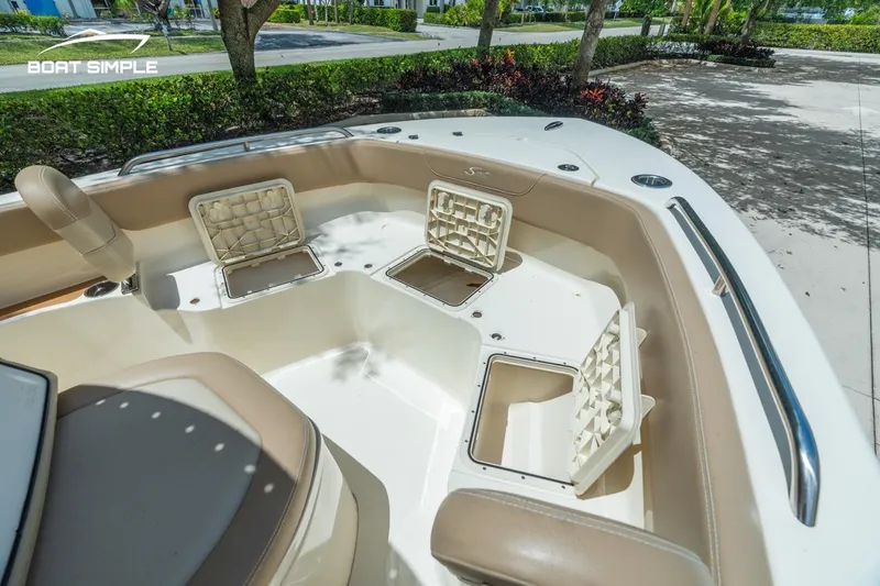 Slide: The Image of 2023 Scout 215 XSF boat interior with open storage compartments and seating. - 12