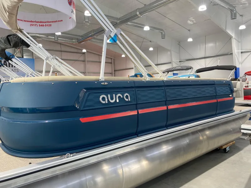 The Image of 2025 Avalon AURA 2385 QL pontoon boat displayed indoors, featuring sleek blue design. - 1