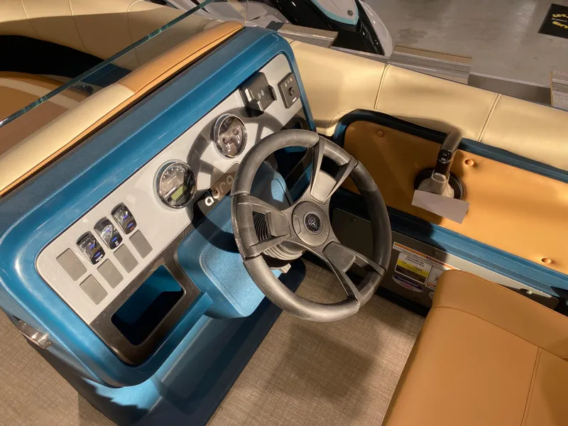 Slide: The Image of Steering console of 2025 Avalon AURA 2385 QL boat with modern controls and beige seating. - 6