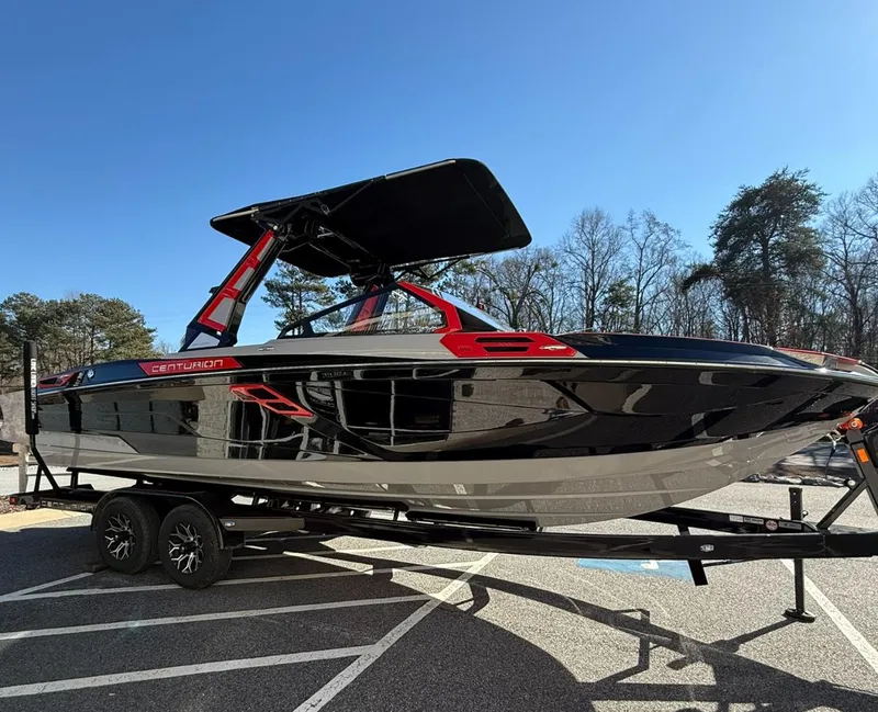 Slide: The Image of 2025 Centurion Ri245 boat on trailer, black and red design, parked outdoors. - 3