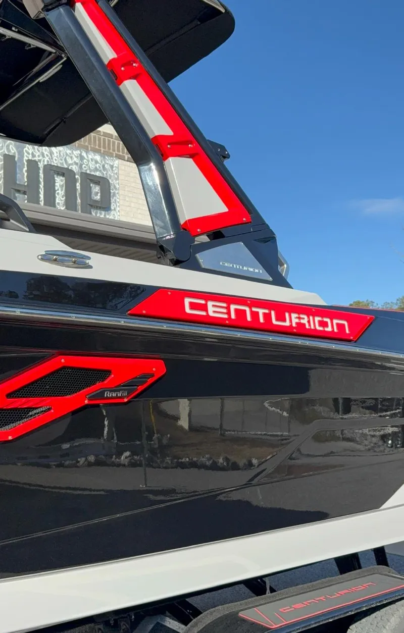 Slide: The Image of 2025 Centurion Ri245 boat with sleek design and red accents under a clear blue sky. - 6