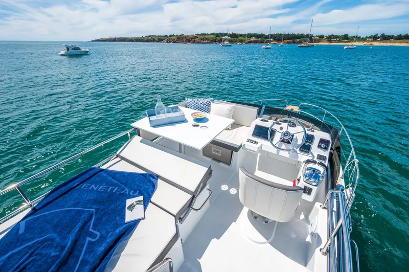 Slide: The Image of 2025 Beneteau Antares 11 Fly yacht on open water, featuring luxurious deck and seating area. - 12