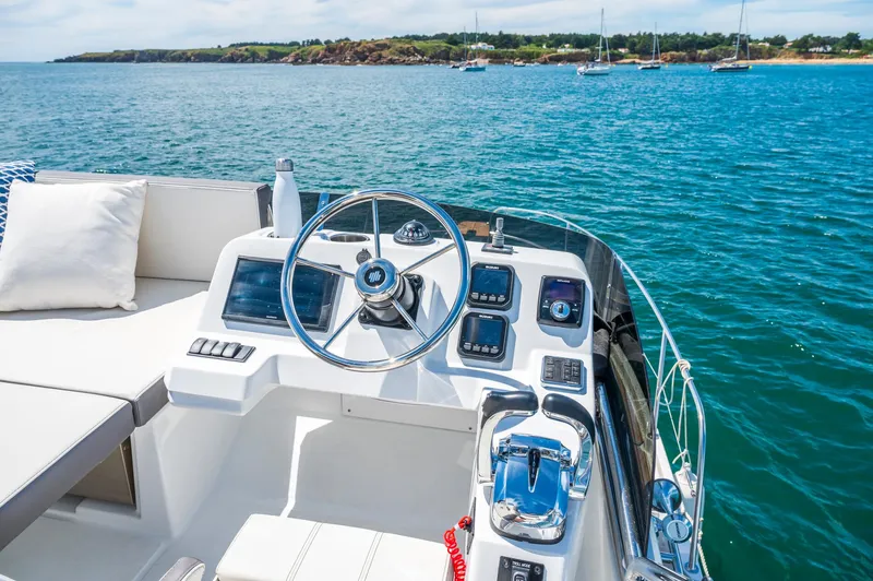Slide: The Image of 2025 Beneteau Antares 11 Fly helm with ocean view, featuring modern controls and comfortable seating. - 13
