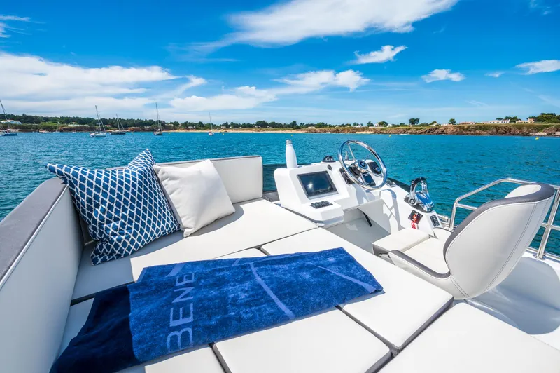 Slide: The Image of 2025 Beneteau Antares 11 Fly yacht interior with plush seating, pillows, and scenic ocean view. - 15