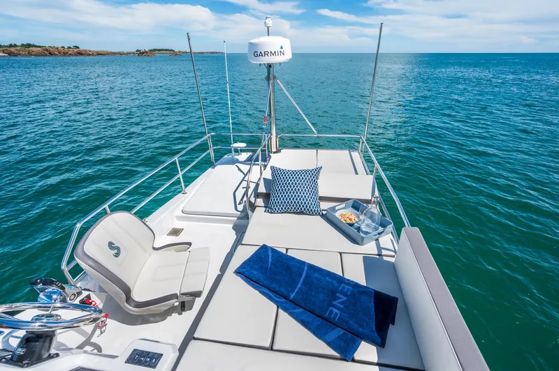 Slide: The Image of 2025 Beneteau Antares 11 Fly yacht deck with sun loungers and ocean view. - 18